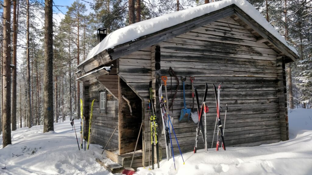Skier an Holzhütte lehnend