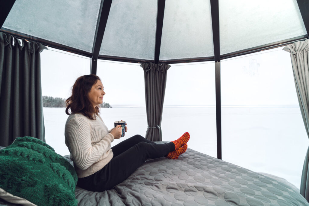 Nainen nauttii kahvia Iglussa Oulujärven jäällä