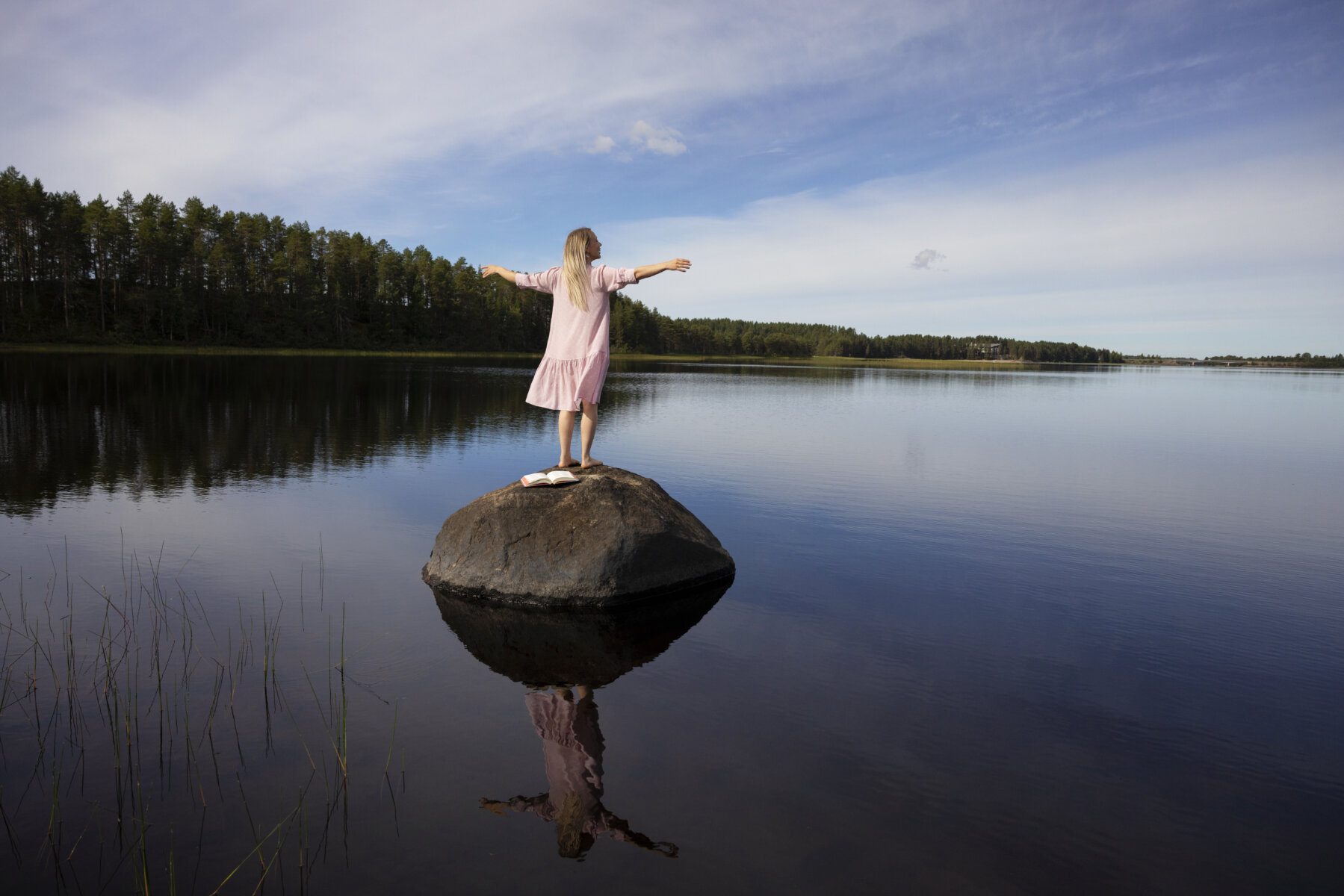 tyttö seisoo kivellä järvellä - girl standing on the rock by lake